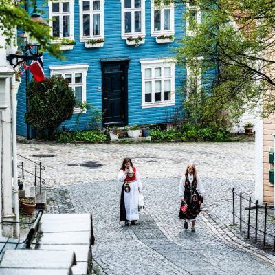 Two Damsels Wearing the Traditional Costume Go Up the Sydneskleiven, Street with Classic Wood Houses in the Ancient Quarter of Sydnes in Bergen