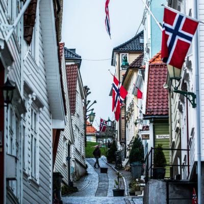 Norwegian Flags Waving from the Front of the Wood Houses in the Quarter of Nordnes